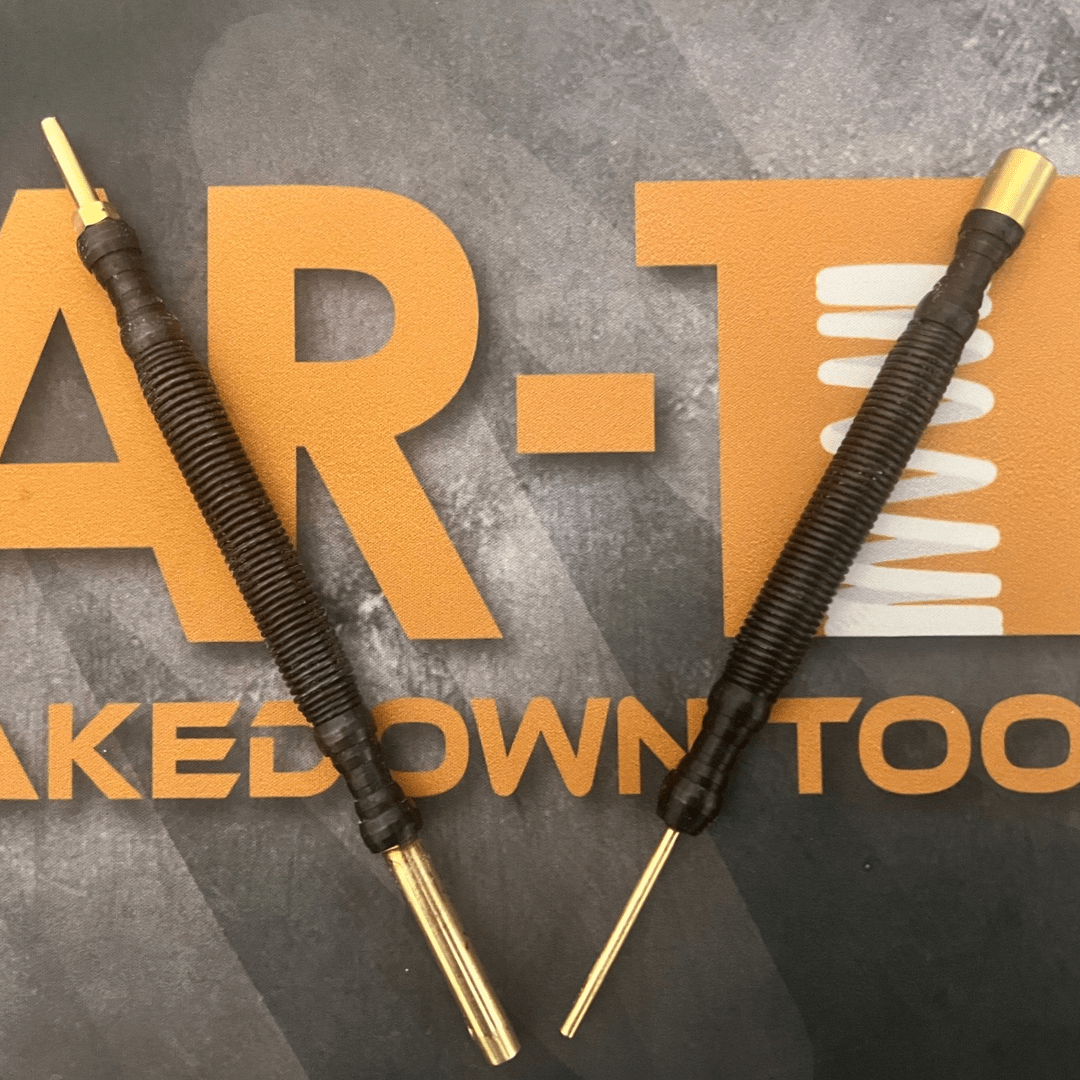 Two brass pin punches laid out on an AR-TT branded tool mat for gunsmithing and maintenance.